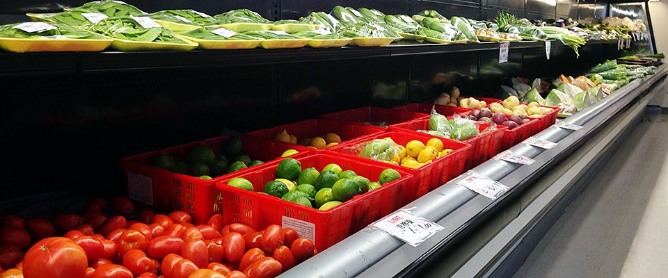 Tomatoes, limes, lemons and fresh vegetables in the produce case