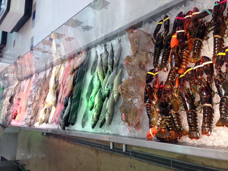 Whole fish and lobsters on ice at the seafood counter